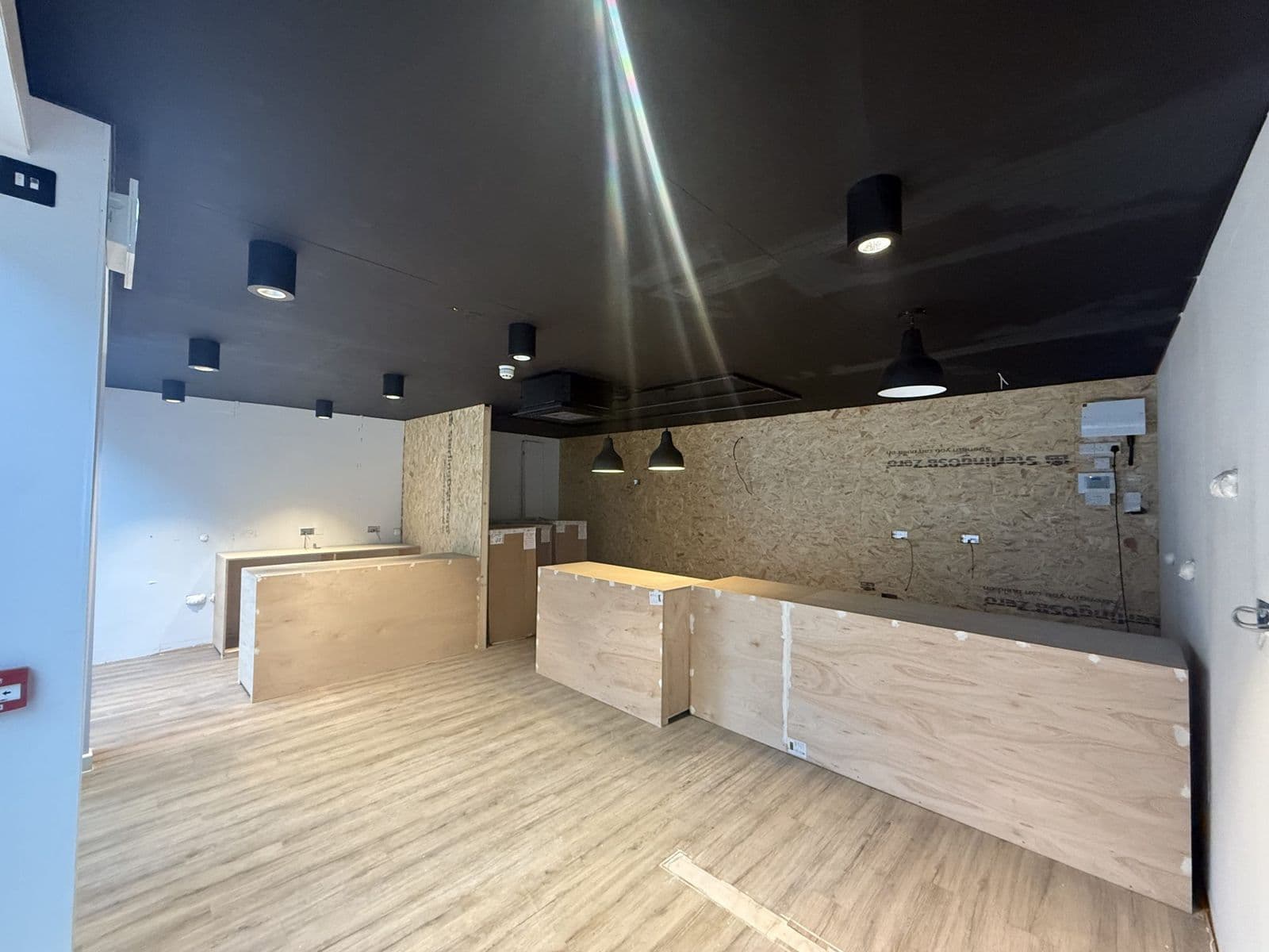 Retail unit fit-out with timber counters and pendant lights